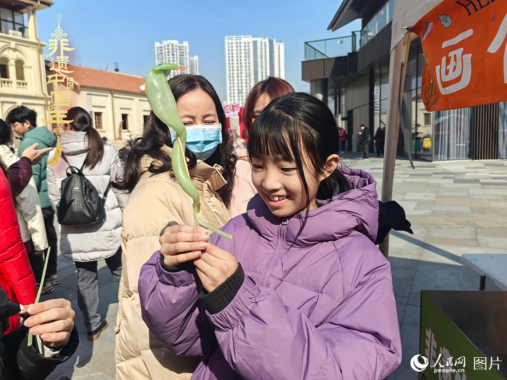2025年1月29日，湖北武漢的新春廟會上，小朋友拿著吹制好的糖人，十分開心。人民網(wǎng)記者 張沛攝