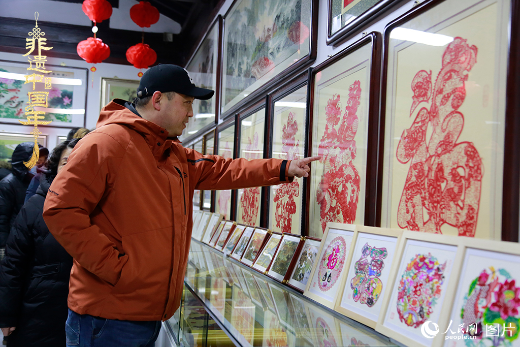 2025年1月23日，游客在天津楊柳青古鎮(zhèn)欣賞傳統(tǒng)剪紙作品，感受指尖上的古老藝術(shù)。人民網(wǎng)記者 崔新耀攝